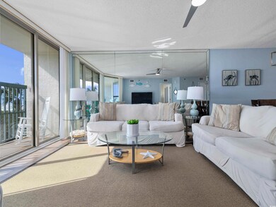 Living room with a textured ceiling, a wall of win