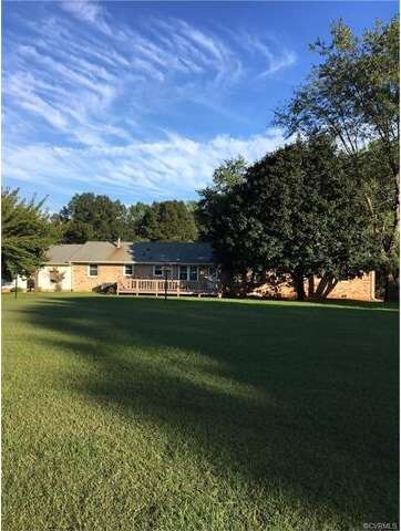 Rear view of home showing large yard.