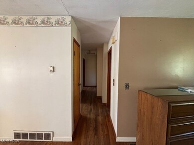 Corridor with dark wood-style floors and baseboards
