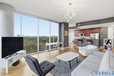 Living area with light wood-type flooring, expansive windows, and a chandelier