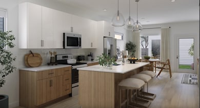 Kitchen featuring stainless steel appliances, an island with sink, a kitchen breakfast bar, tasteful backsplash, and hanging light fixtures