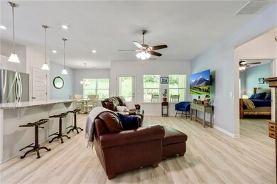 Living room featuring a ceiling fan, light wood-type flooring, and recessed lighting