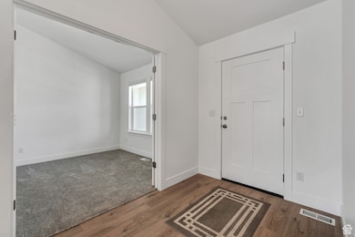 Entrance foyer featuring vaulted ceiling and dark wood finished floors