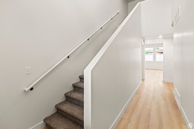 Stairway with wood finished floors and recessed lighting