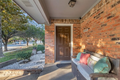 View of exterior entry with brick siding and covered porch