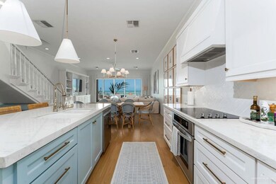 Kitchen featuring stainless steel appliances, white cabinets, open floor plan, tasteful backsplash, and a chandelier