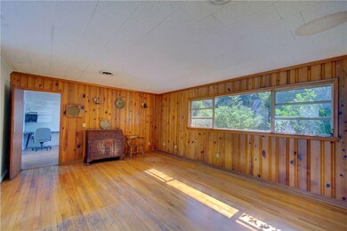 Large family room with oak floors and wood panelin