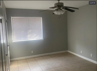 Tiled spare room with ceiling fan and baseboards