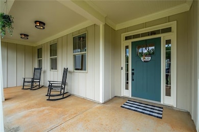 Property entrance with a porch and board and batten siding