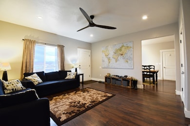 Living room featuring dark wood-style floors, recessed lighting, and a ceiling fan