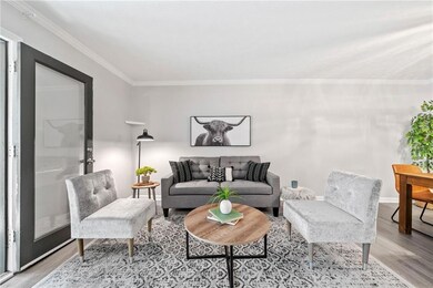 Living room featuring wood finished floors, ornamental molding, and baseboards