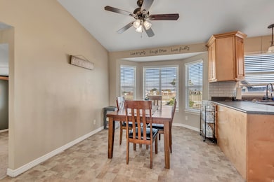Dining room with ceiling fan and vaulted ceiling
