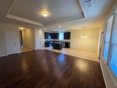 Unfurnished living room featuring a raised ceiling, a chandelier, light wood-style floors, ornamental molding, and recessed lighting