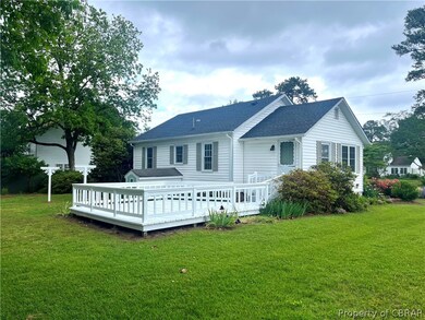 Back of house featuring a deck and a lawn