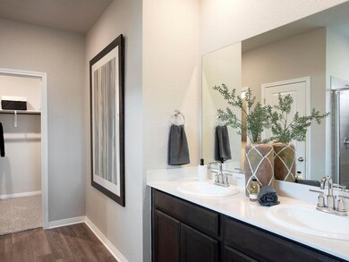 Bathroom with double vanity, wood finished floors