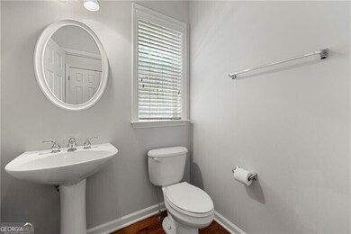 Half-Bathroom featuring toilet and wood finished floors