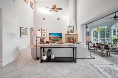 Living room with ceiling fan, a high ceiling, and 