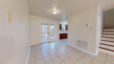 Tiled spare room featuring sink and french doors