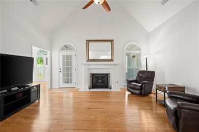 Living area with high vaulted ceiling and a tiled fireplace