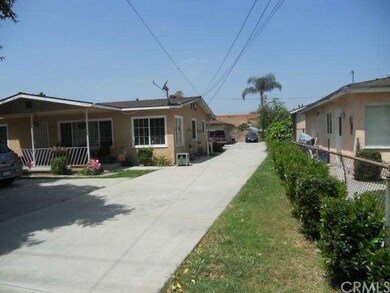 Front house with driveway leading to back house and garage.