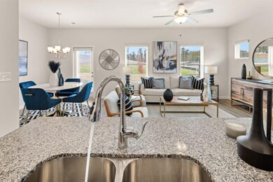 Living room with wood finished floors, ceiling fan, and a chandelier