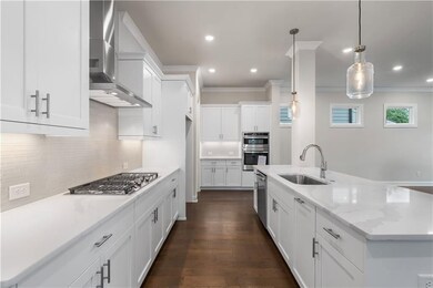 GE Stainless Steel appliances include range hood, gas stove top, microwave/oven combo and dishwasher.