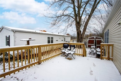 Snow covered deck featuring a storage shed
