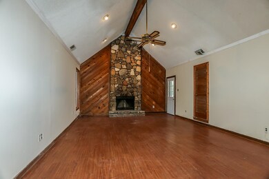 Unfurnished living room featuring a stone fireplac