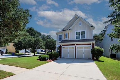 Craftsman-style house with board and batten siding, a garage, driveway, and a front lawn