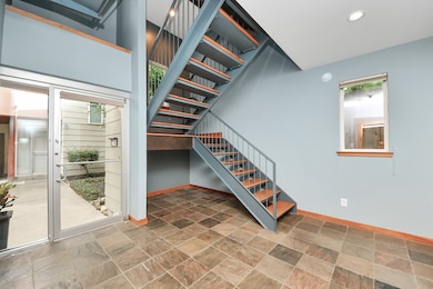 Welcome home to a bright and spacious foyer with modern tile flooring and a sleek staircase, offering a stylish entrance from the garage.