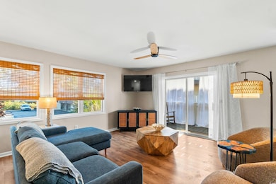 Living room featuring ceiling fan, baseboards, and
