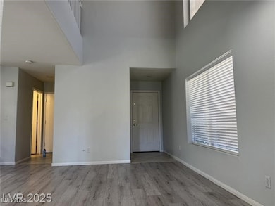Unfurnished room with a high ceiling, wood finishe