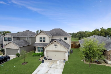 Traditional-style house featuring a front lawn, driveway, a shingled roof, and board and batten siding