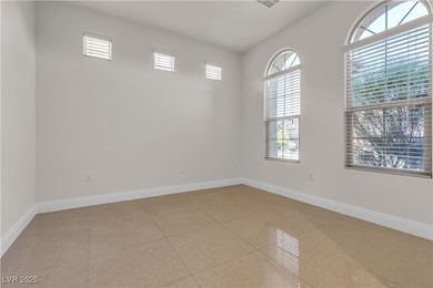 Empty room with healthy amount of natural light and light tile patterned floors