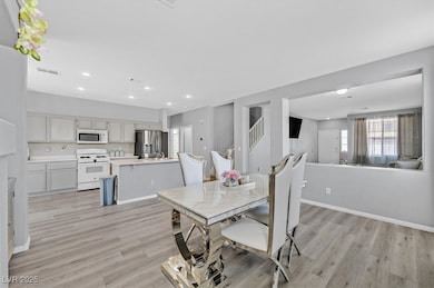 Dining area featuring light wood finished floors, recessed lighting, and stairway