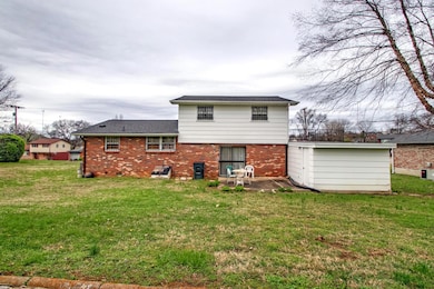 Rear view, concrete patio. Storage/workshop accessed from carport.