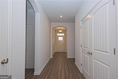 Hallway featuring arched walkways, dark wood-style