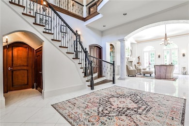 Entrance foyer opens to formal living room. Door under archway leads to library/office.