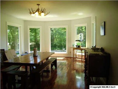 The Large Dining Area with New Windows, Hardwoods, and Antler Light Fixture