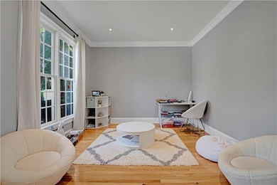 Office with light wood-style flooring, crown molding, and recessed lighting