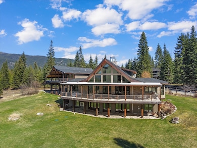 Back of house with a lawn and a wooden deck