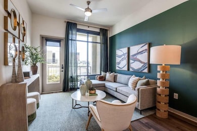Sitting room with ceiling fan and wood-type floori
