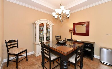 Dining room offers a tray ceiling, crown molding a