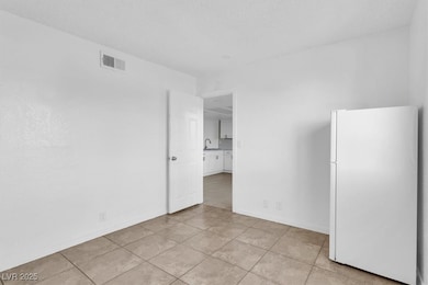 Unfurnished room featuring light tile patterned floors and a textured ceiling