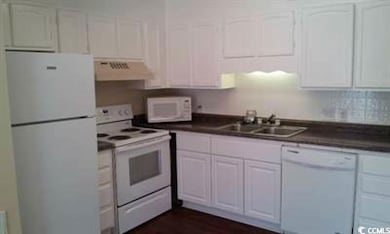 Kitchen featuring white appliances, ventilation hood, a sink, and white cabinets
