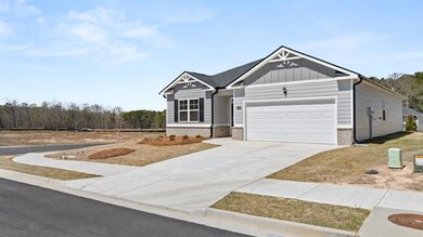 Craftsman house featuring brick siding, board and batten siding, a garage, and driveway