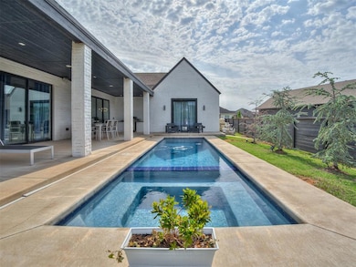 View of pool featuring a fenced backyard, a patio, outdoor dining area, and a pool with connected hot tub