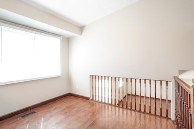 Spare room featuring wood finished floors and baseboards