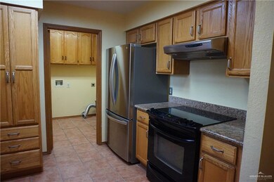Kitchen featuring dark stone countertops, light tile patterned floors, and black electric range