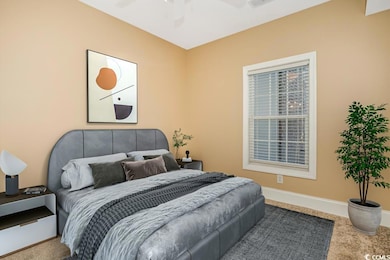 Carpeted bedroom with ceiling fan, baseboards, and
